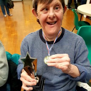A photo of Michael holding his first place medal, plus the trophy