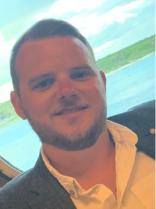 A man in a white shirt and grey blazer