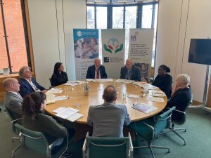 Nine people sat around a circular table