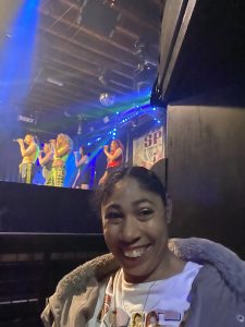 Dionne smiling alongside the stage at the Spice Girls concert