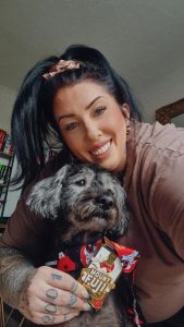 Sacha smiling with her dog and Mount Fuji challenge medal