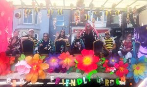 A carnival float decorated in colourful paper flowers