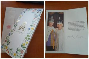 A card decorated in colourful flowers from King Charles. It reads, 'We were deeply touched by your most kind and thoughtful message following our Coronation. We are enormously grateful to everyone who took part in the celebrations, and particularly appreciate that you so generously took the time to write to us on this very special occasion.'