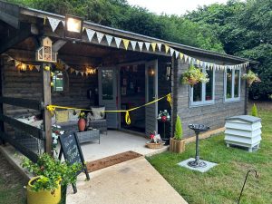 A photo of a wooden summerhouse decorated in bunting.