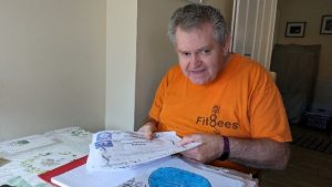 Gordon wearing an orange shirt with the FitBees logo