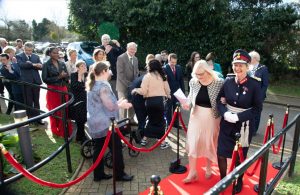 Lord-Lieutenant and Claire walking down the red carpet outside of the home