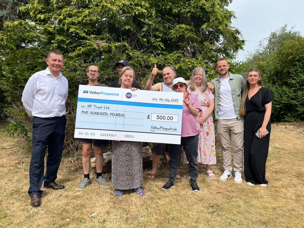 Ian, VolkerFitzpatrick staff and people Hft supports stand in a group with a big blue and white cheque.