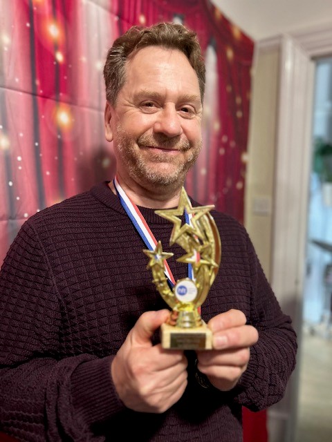 Gerard holding his trophy which features three gold shooting stars.