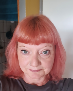 Mel has shoulder length pink hair.