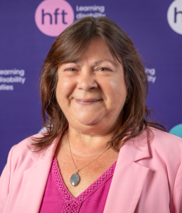 Vicky has medium length, straight brown hair. She's wearing a light pink jacket and a hot pink top.